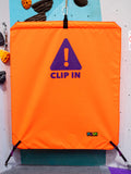 Orange belay gate reading CLIP IN by Neon Climbing Accessories.