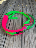 Neon green and pink should climbing and racking sling on a wooden surface